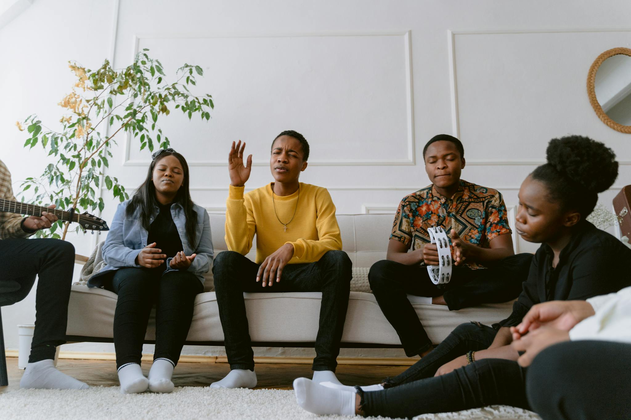 A diverse group of friends enjoying music together in a cozy living room setting.