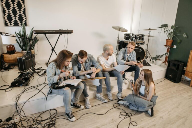A group of young musicians practicing in a modern studio with various instruments.