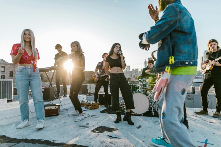 Group of young musicians performing live on a rooftop with city skyline backdrop.